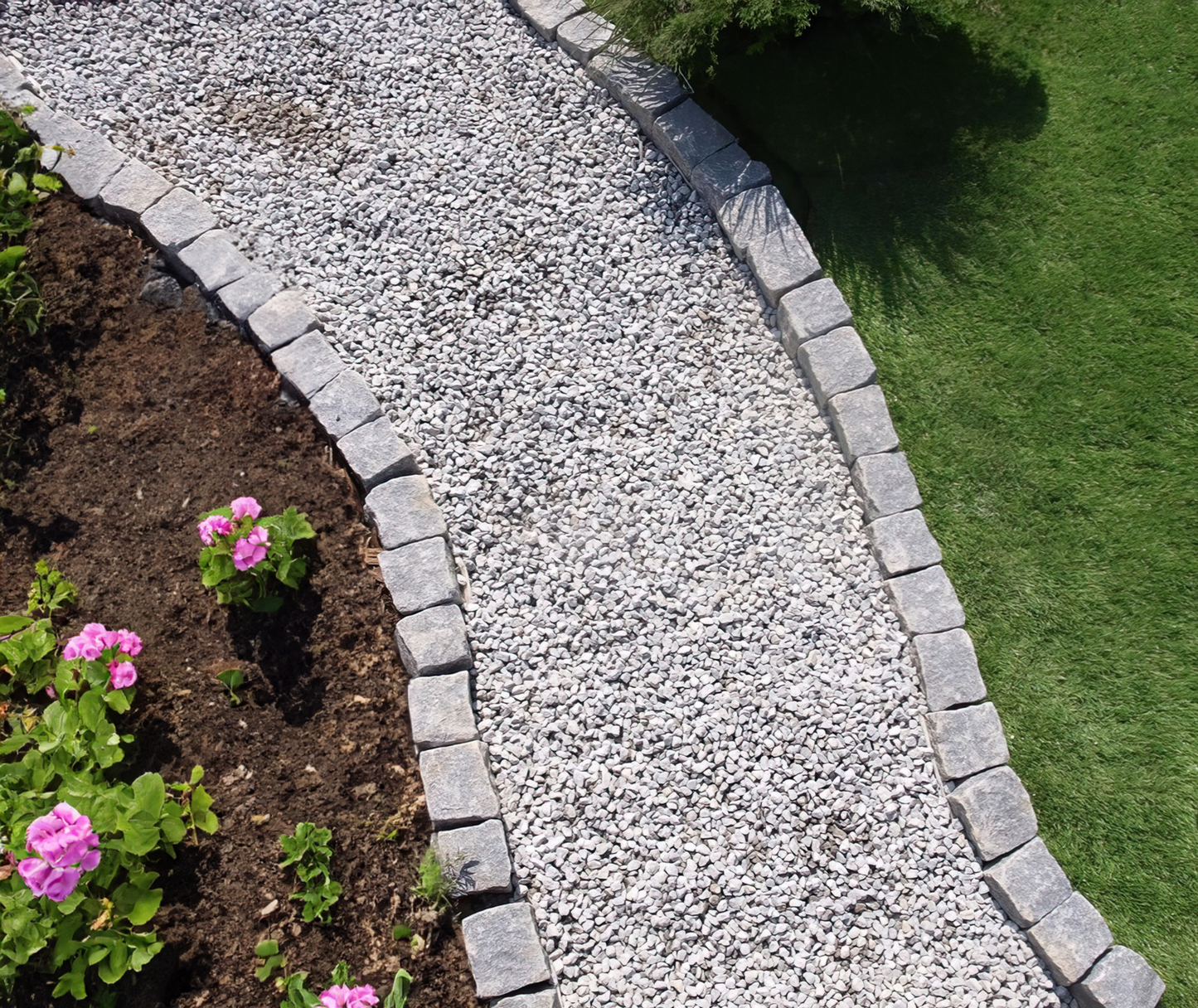 a stone path with flowers in the middle of it
