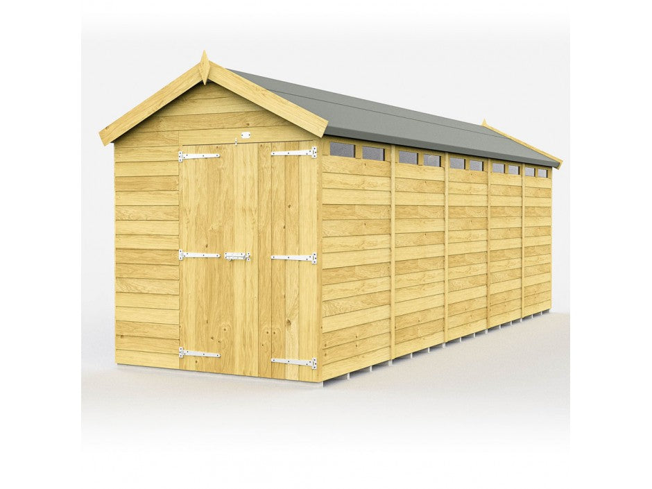 The ShedsDIY Apex Shed 7ft wide is a large wooden structure with a pitched roof, multiple small windows near the top, tongue and groove construction, double doors with metal hinges at one end, and a light-colored wood panel exterior.