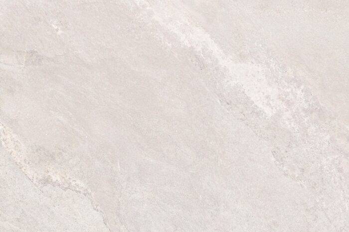 A close-up of a beige stone surface mimics the refined look of Agra White Porcelain Paving from Brisks, featuring subtle texture and color variations. Its smooth, matte finish offers slip resistance, making it ideal for naturally and elegantly enhancing outdoor spaces.