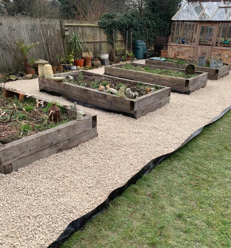 a row of raised garden beds sitting on top of a lush green field