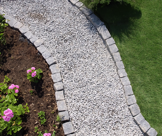 a stone path with flowers in the middle of it