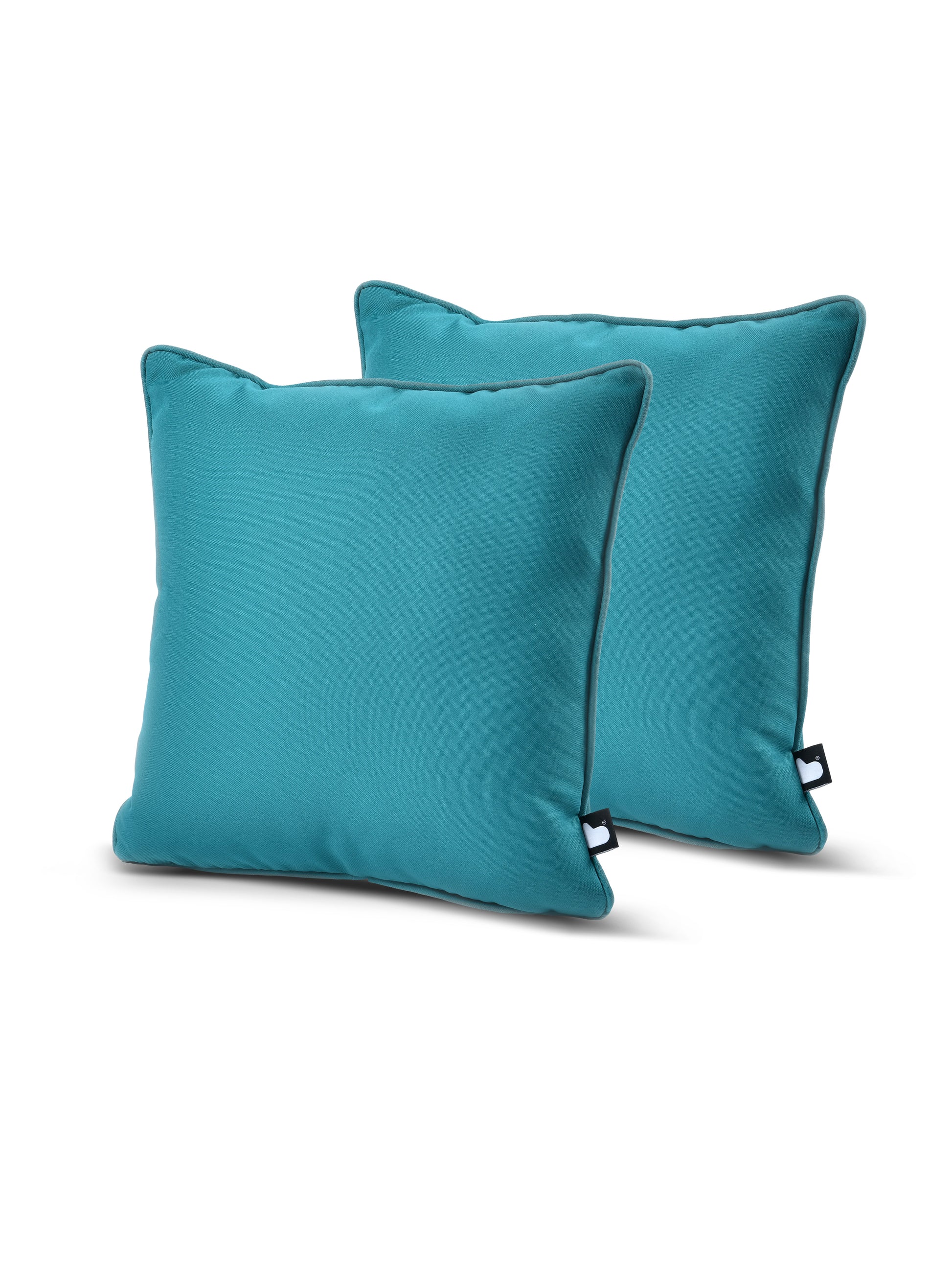 Two teal-colored square pillows are placed at slight angles against a plain white background. Both pillows, made from breathable polyester, have a smooth texture with a small black tag on the side edge. Their simple and modern design suggests an aesthetic and comfortable addition to home decor. These are part of the Brisks B Cushion Twin Pack Brights Collection.