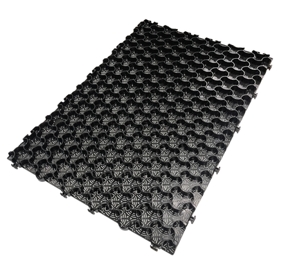 The CORE COMMERCIAL 75-30 - Gravel Grid by Core LP is a black, rectangular interlocking mat with a floral grid pattern that enhances gravel stabilization. Its textured, raised surface offers a uniform, decorative look ideal for managing commercial traffic and is displayed on a white background.