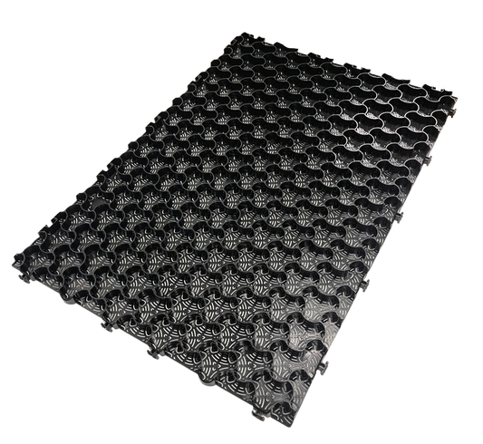 The CORE COMMERCIAL 75-30 - Gravel Grid by Core LP is a black, rectangular interlocking mat with a floral grid pattern that enhances gravel stabilization. Its textured, raised surface offers a uniform, decorative look ideal for managing commercial traffic and is displayed on a white background.