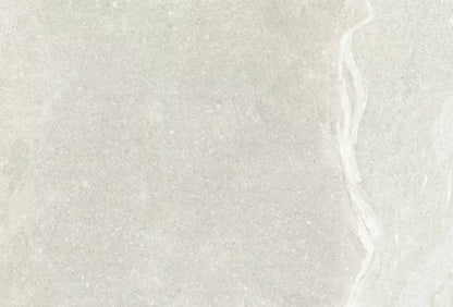 The Kiara Perla Porcelain Paving by Brisks features a light gray textured stone surface with subtle variations and a faint, irregular white vein running vertically on the right side, making it perfect for outdoor spaces. Its slip-resistant finish ensures safety while maintaining a stylish appearance.
