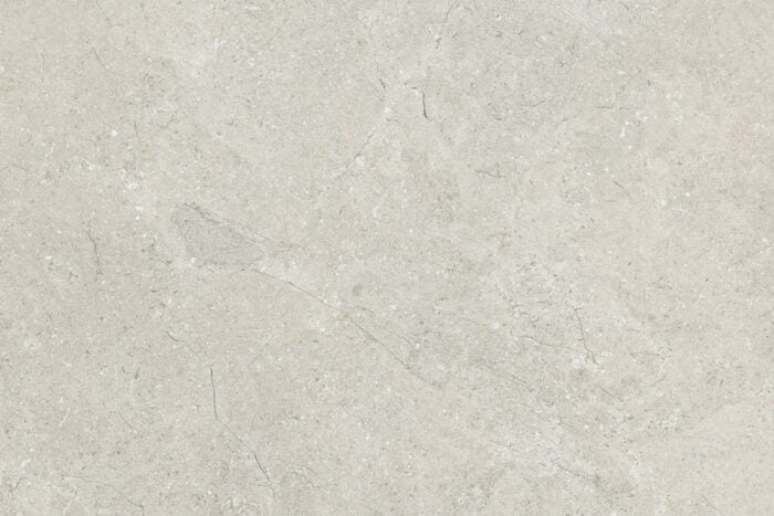 The Brisks Next Marfil Porcelain Paving tiles boast an elegant design with a textured light gray stone surface. Their subtle color variations and delicate natural veins enhance their beauty, while their exceptional durability ensures long-lasting performance, closely resembling premium stone or concrete materials.