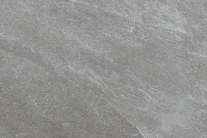 A close-up of a gray, textured stone surface with subtle variations in shade and rough, natural patterns, reminiscent of Brisks' Rasa Grigio Porcelain Paving tiles known for their premium durability.