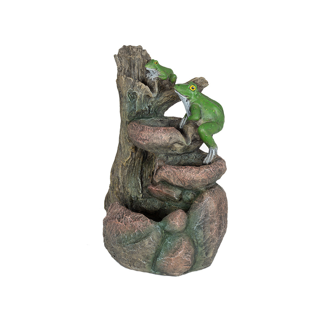 A charming small sculpture from La Hacienda's "Frog Pools" collection makes an ideal garden accessory, showcasing two green frogs perched on a rustic, rocky structure that looks like a tree stump. The piece is intricately detailed with textured bark and stone surfaces, enhancing its natural appeal.