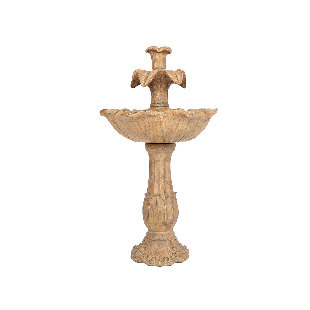 The Emily Tiered Fountain by La Hacienda is a decorative stone piece with an ornate, two-tiered design. It features a pedestal base and scalloped basin, and the top resembles a flower. This garden focal point adds a weathered, rustic charm to any outdoor area.