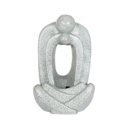 The La Hacienda Zen Pour Water Feature by La Hacienda is a contemporary sculpture featuring an abstract figure sitting with legs crossed. Crafted from weather-resistant polyresin, the minimalist design includes a smooth surface and a large, oval-shaped hollow in the torso area. The overall texture of the Zen Pour Water Feature is speckled grey.