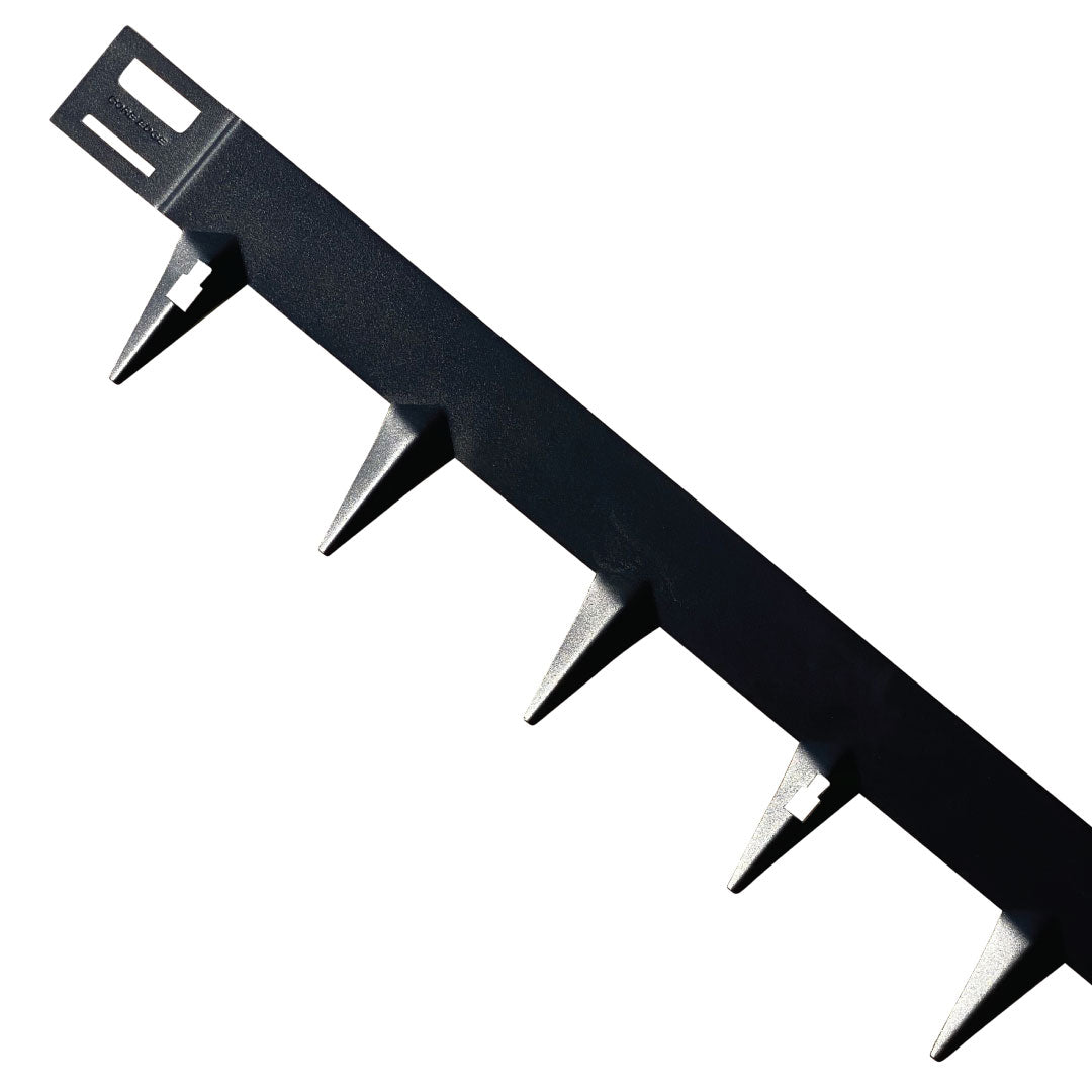 The black plastic stake strip features triangular spikes along its length, perfect for securing flexible steel garden edging in landscaping projects. The durable CORE EDGE by Core LP is an ideal outdoor solution for any DIY garden project. Shown on a white background.