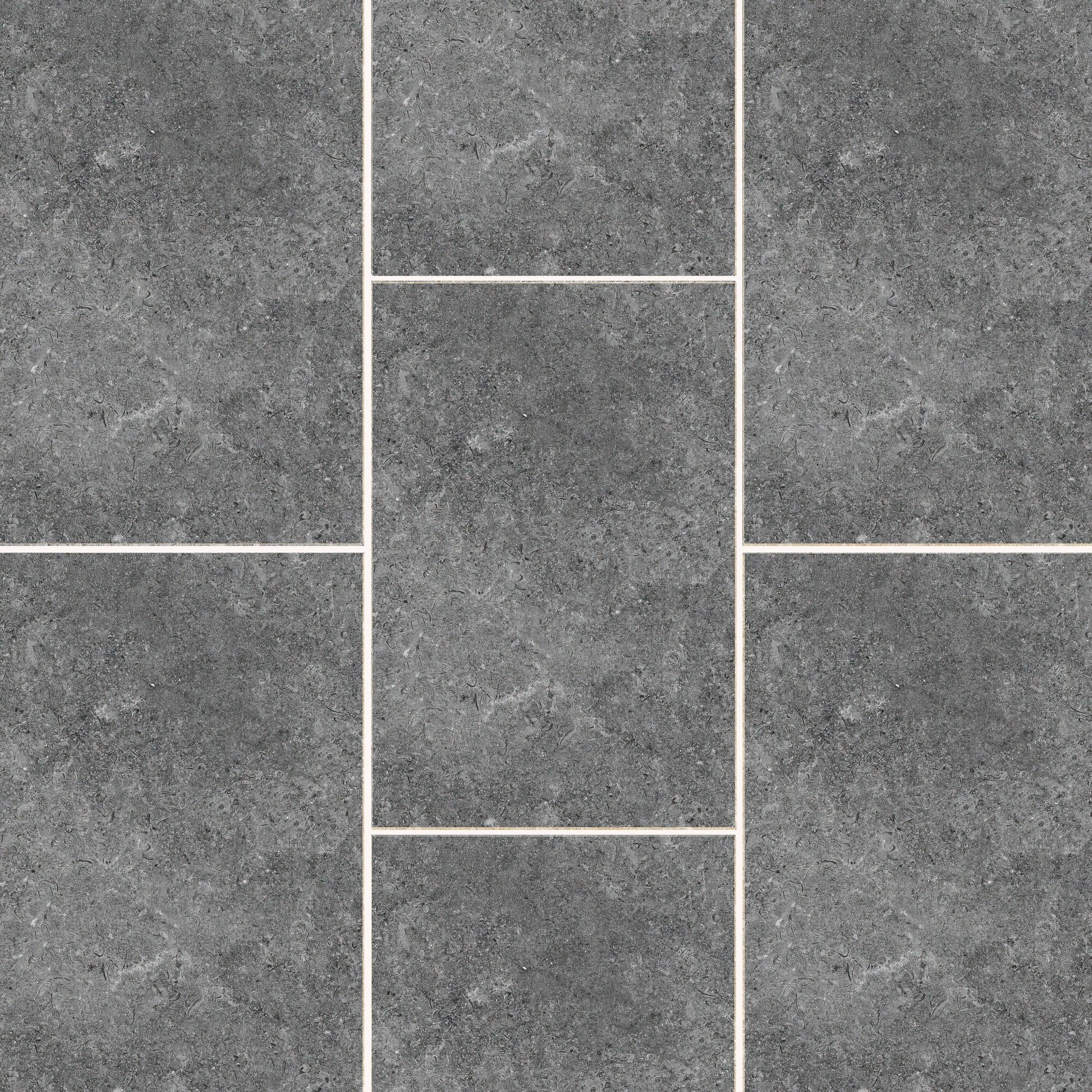 A textured gray tile pattern with pale grout lines. The Carmen Anthracite Porcelain Paving Slabs from Brisks are arranged in a staggered fashion with varied rectangular and square shapes, creating a uniform yet visually engaging surface. The sleek finish has a slight mottled appearance, adding depth to the Brisks Carmen Anthracite tones.
