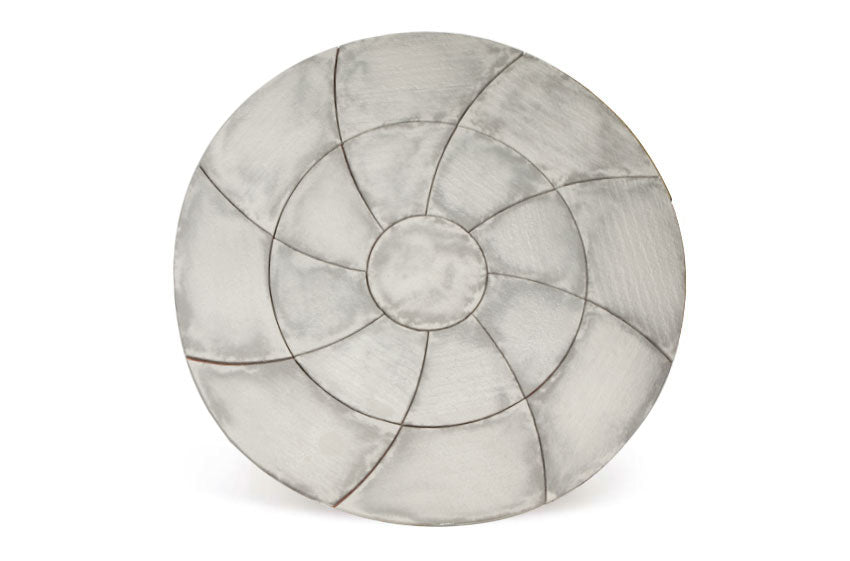 A round, flat Weathered Slate Catherine Wheel Kit by Bowland Stone from Brisks, boasting an intricate spiral pattern of curved segments radiating from a central point, resembling a stylized flower or geometric design. The surface appears smooth and slightly reflective, akin to weathered slate.