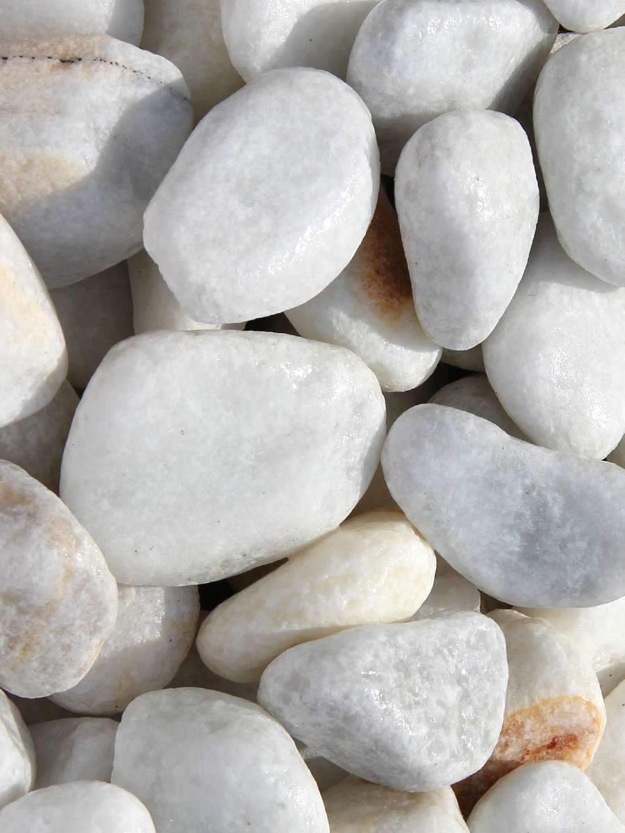 Experience the elegance of Brisks' 20-40mm White Pebbles in a close-up view. The smooth stones vary slightly in size and shape, featuring occasional light brown patches. Packed closely together, they form a textured mosaic of natural, polished surfaces—perfect for landscaping projects.