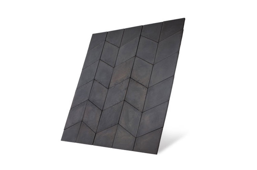 A flat panel displaying a herringbone pattern of dark grey, slightly textured tiles. The panel is tilted at an angle, showcasing its geometric and repetitive design, reminiscent of the elegance found in the Brisks Welsh Slate Prestbury Chevron Patio Kit by Bowland Stone.