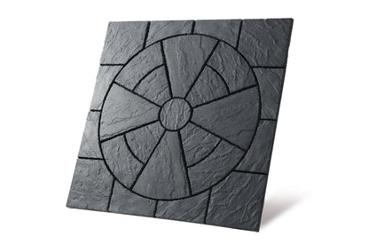 A square, textured black Brisks Welsh Slate Rectory Circle Patio Kit by Bowland Stone features a circular pattern in the center with radiating segments. The tile has a natural, rough finish and distinct grooves outlining the geometric design, perfect for garden landscaping with this kit. The background is plain white.