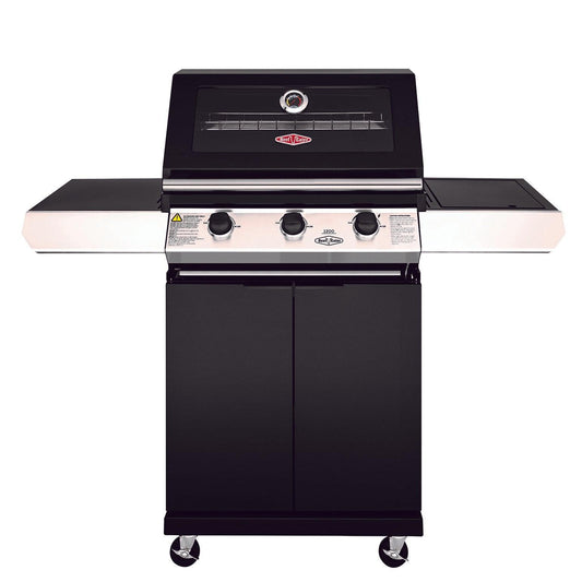 The Brisks BeefEater 1200E Series 3 Burner BBQ & Trolley features three control knobs, a thermometer on the lid, and a see-through glass window. This 3 Burner BBQ offers side shelves for additional space and is mounted on a black cabinet with wheels for mobility. Perfect for luxurious outdoor living, the Brisks logo is visible on the front.