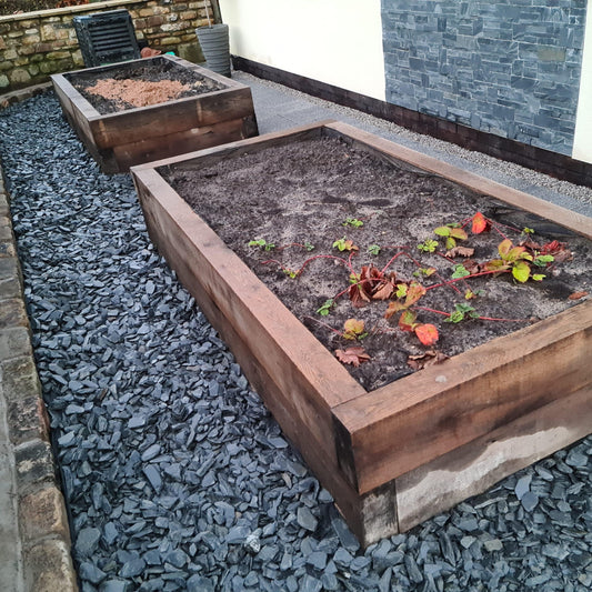 a wooden box filled with dirt and plants