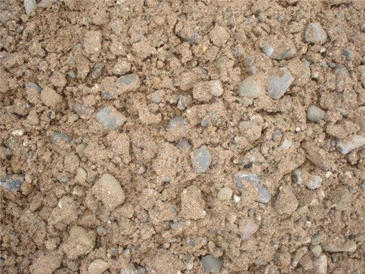 A close-up view of a mixture of sandy soil and small rocks, ideal for construction applications. The color is predominantly light brown with various Brisks 20mm All In Ballast Aggregate stones scattered throughout. The rough and uneven texture suggests suitability for concrete projects.