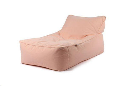 A soft, peach-colored bean bag chair with an inclined backrest is displayed against a plain white background. The Brisks Extreme Lounging B-Bed Pastel appears cushioned and comfortable, suitable for lounging or relaxing in your garden retreat.