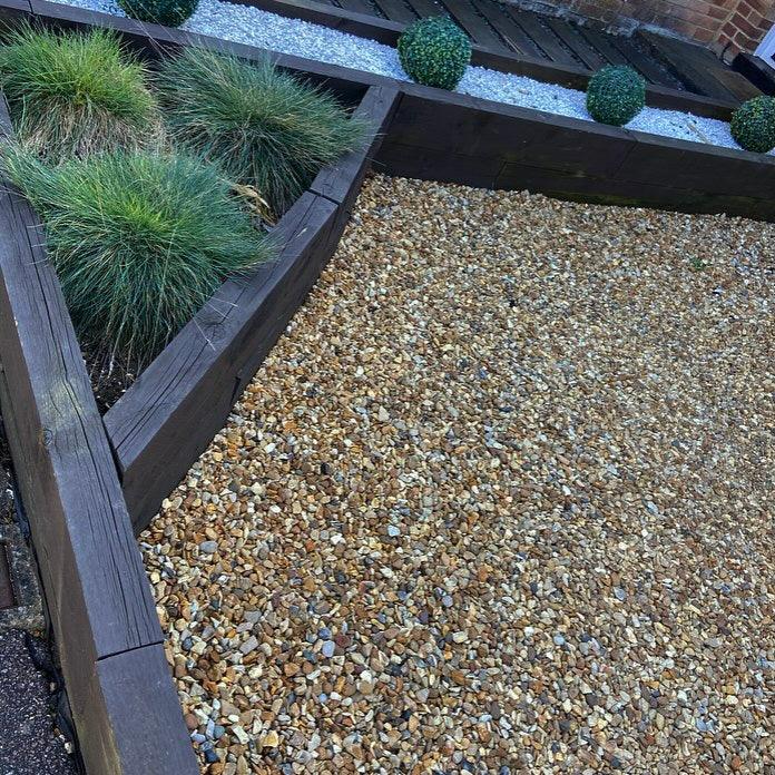 a wooden planter filled with lots of gravel