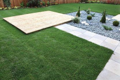 a backyard with a wooden deck and grass