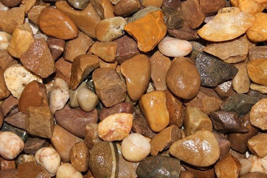 An assortment of smooth, multicolored stones and pebbles in various shades of brown, beige, gray, and white, closely packed together, showcasing a variety of textures and shapes—perfect for adding decorative gravels to your outdoor landscape with options like Brisks 20mm Trent Valley Gravel.