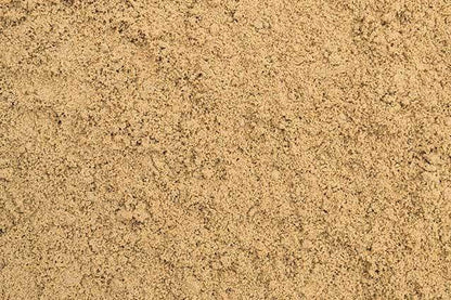 A close-up image of fine, dry sand reveals a uniform texture and light beige hue, perfect for horse arena flooring. The smooth, even appearance speaks to the superior quality of Brisks Equestrian Sand, free from distinct objects or patterns.