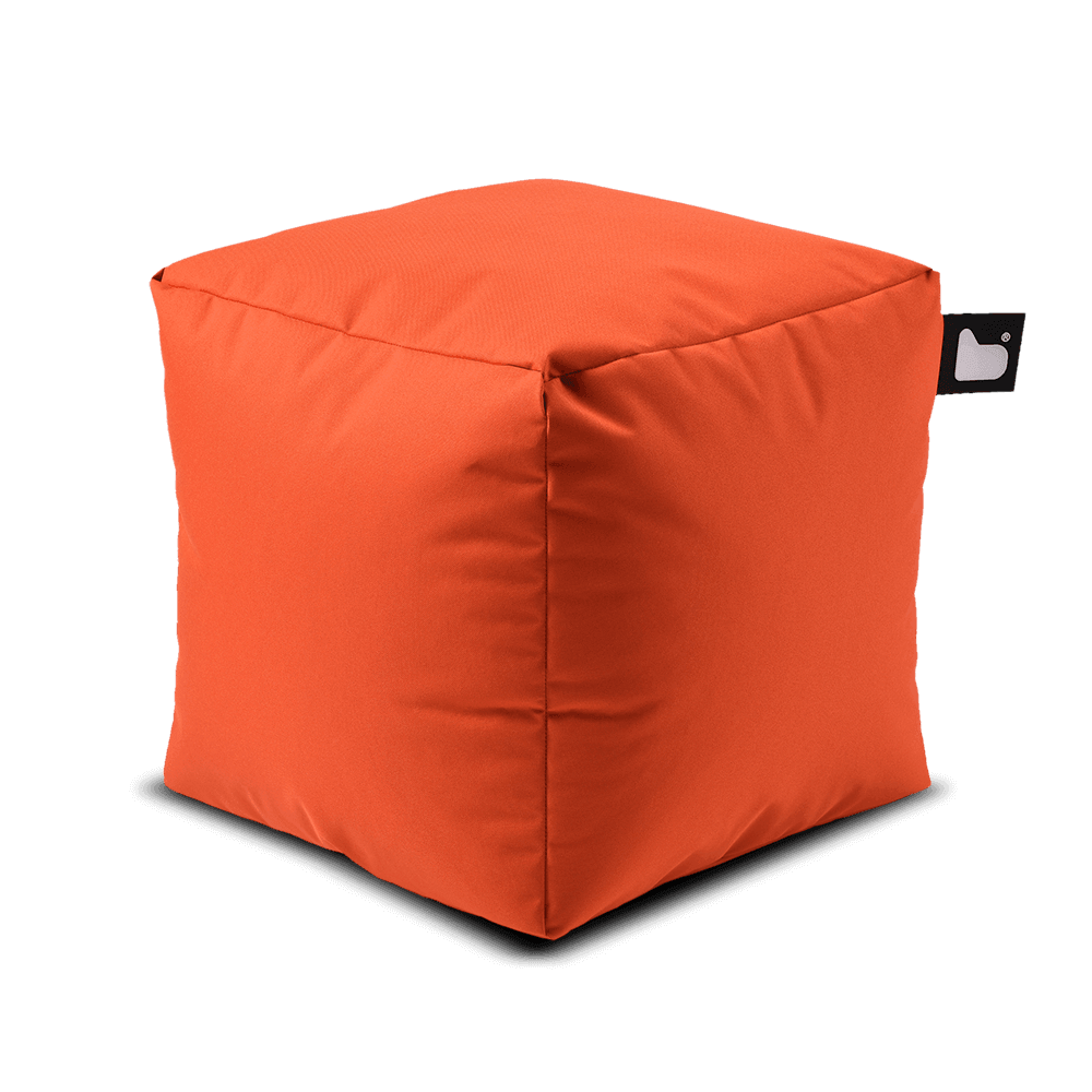 A bright orange, cube-shaped Brisks Extreme Lounging Outdoor B-Box with a small black tag on one corner. Filled with polystyrene beads, the fabric appears soft and slightly textured. The Extreme Lounging Outdoor B-Box stands out against the plain background, showcasing its simple, modern design perfect for a garden retreat.