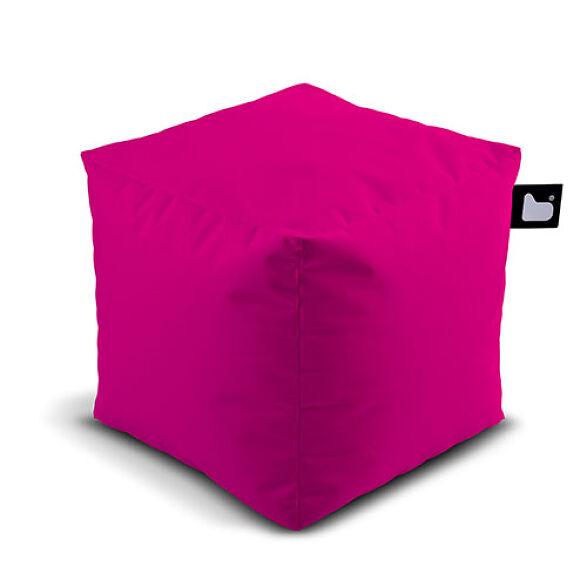 A vibrant pink, cube-shaped Brisks Extreme Lounging Outdoor B-Box pouf with a slightly wrinkled fabric surface. Filled with Polystyrene Beads, it features a small black tag adorned with a white heart logo on one of its edges. The pouf casts a subtle shadow beneath it, making it perfect for any garden retreat.