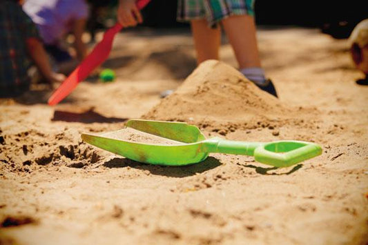 a child's toy shovel and shovel in the sand