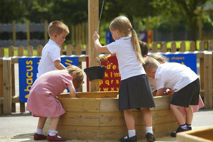 a group of children playing with a wooden boat